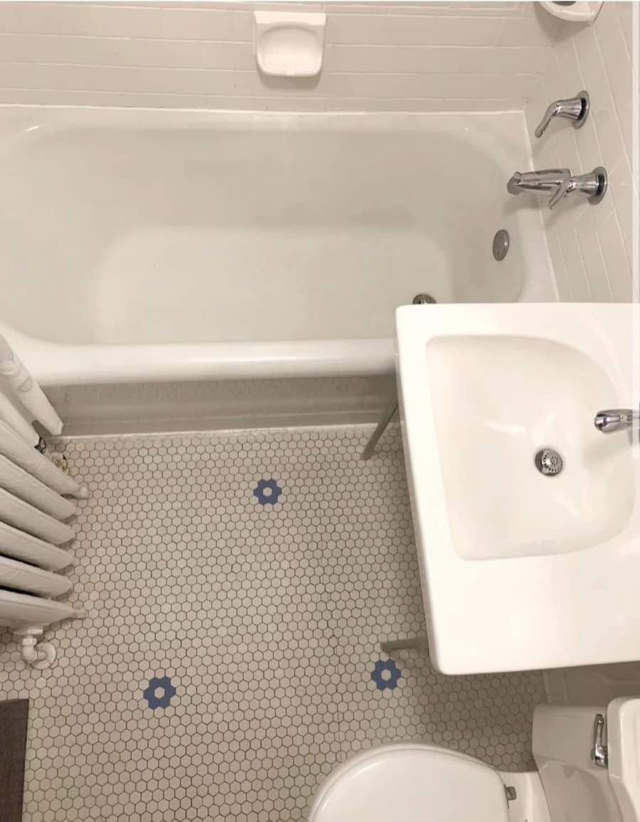 White bathtub and sink with hexagonal tile floor