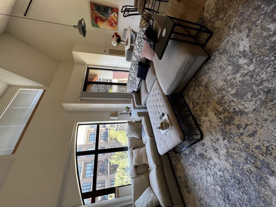Living room with light sofas and tall windows