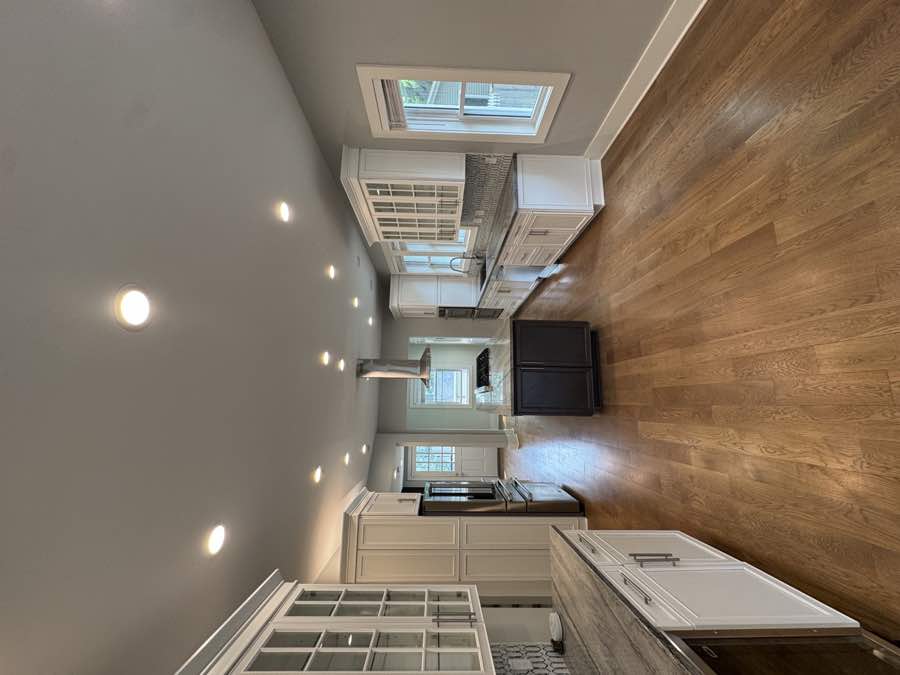 White kitchen with central island and wood floors