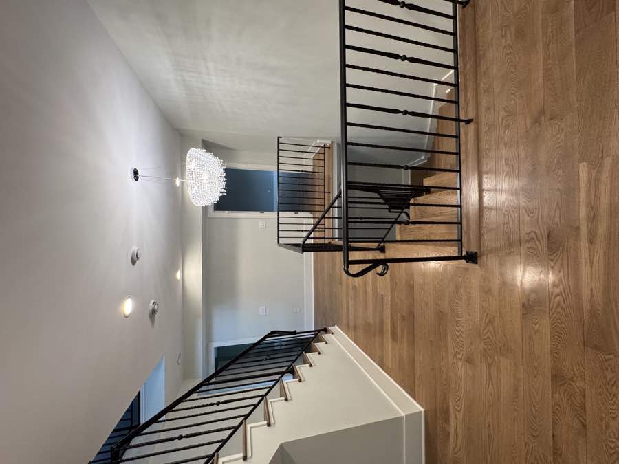 Stair landing with chandelier and black railings