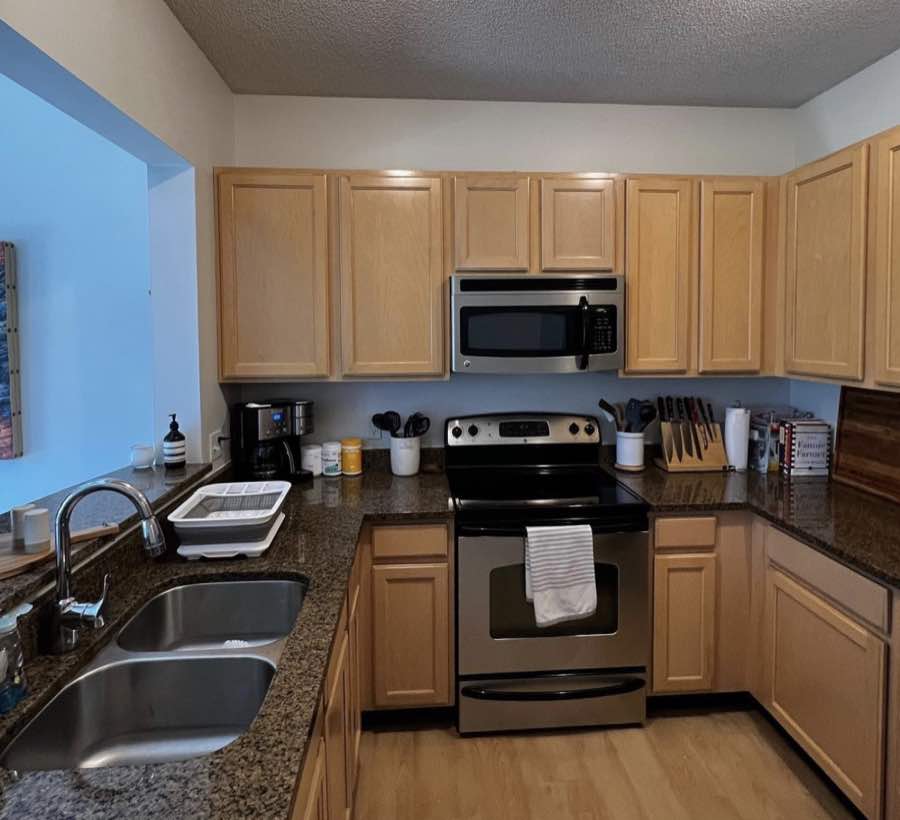 Clean kitchen with wood cabinets, stainless steel appliances, and a double sink