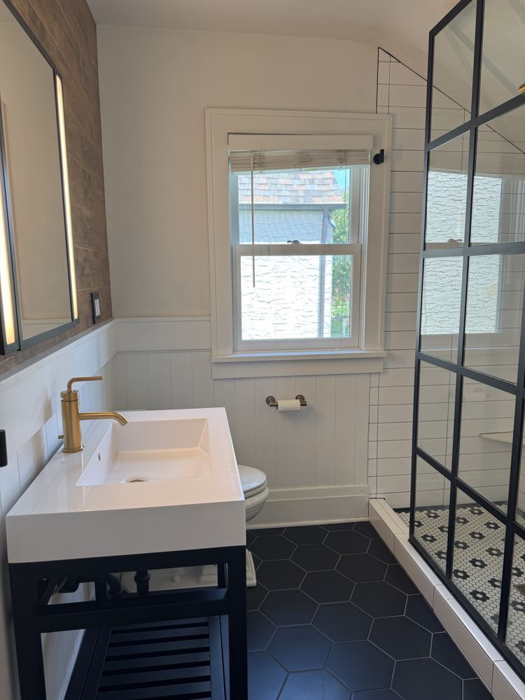 Clean bathroom with white vanity and glass shower